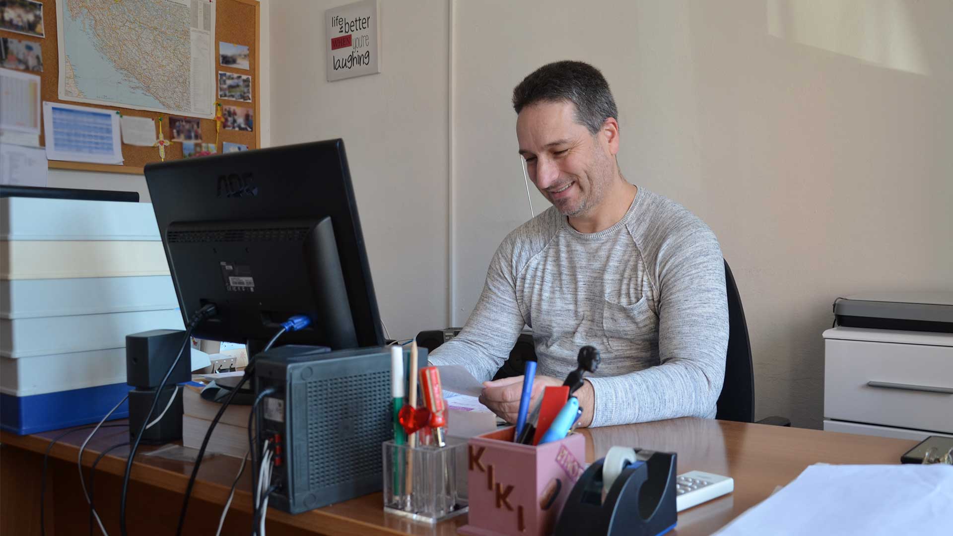 A man sat at a desk on a computer.