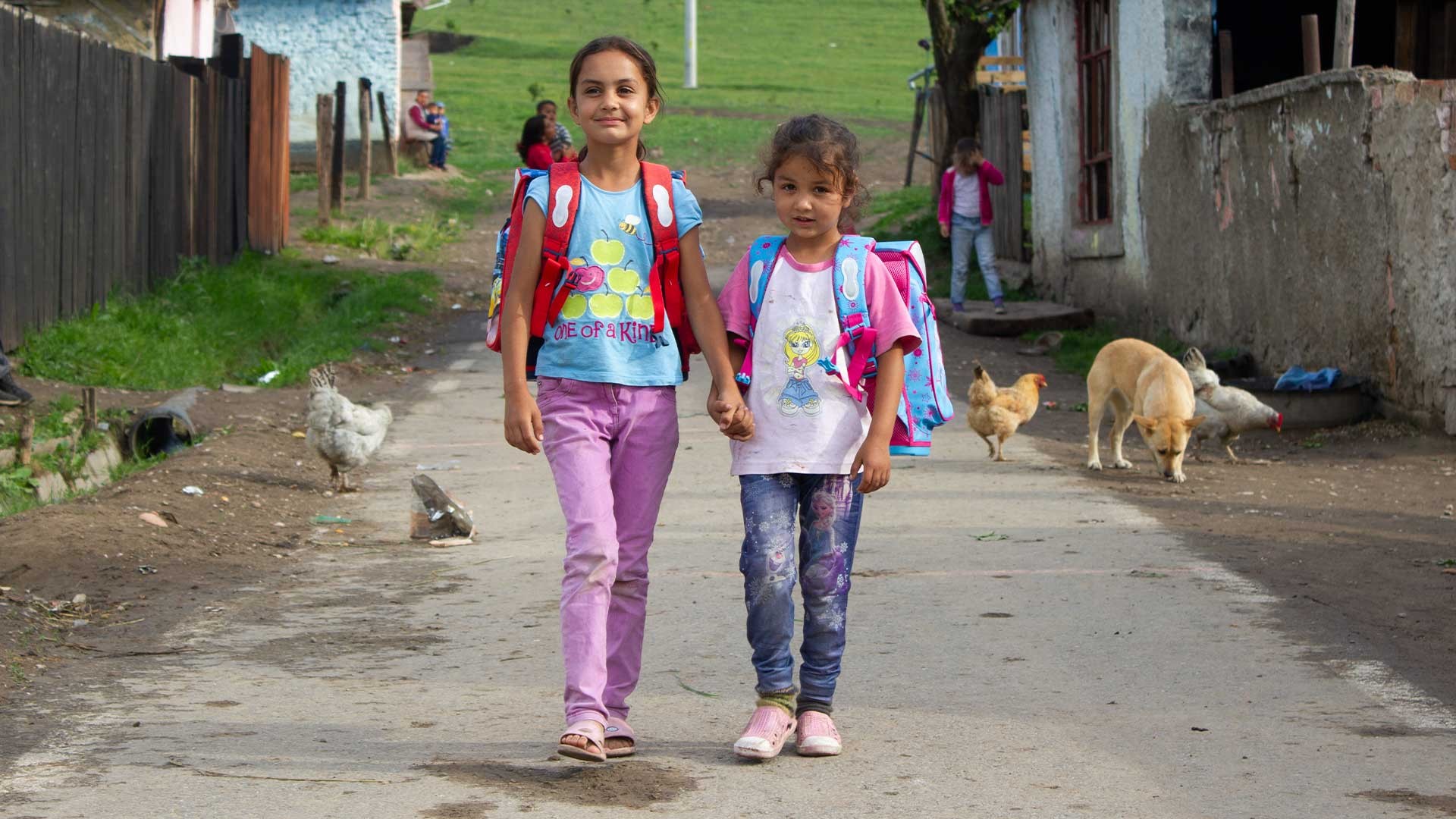 Two girls walk down a street