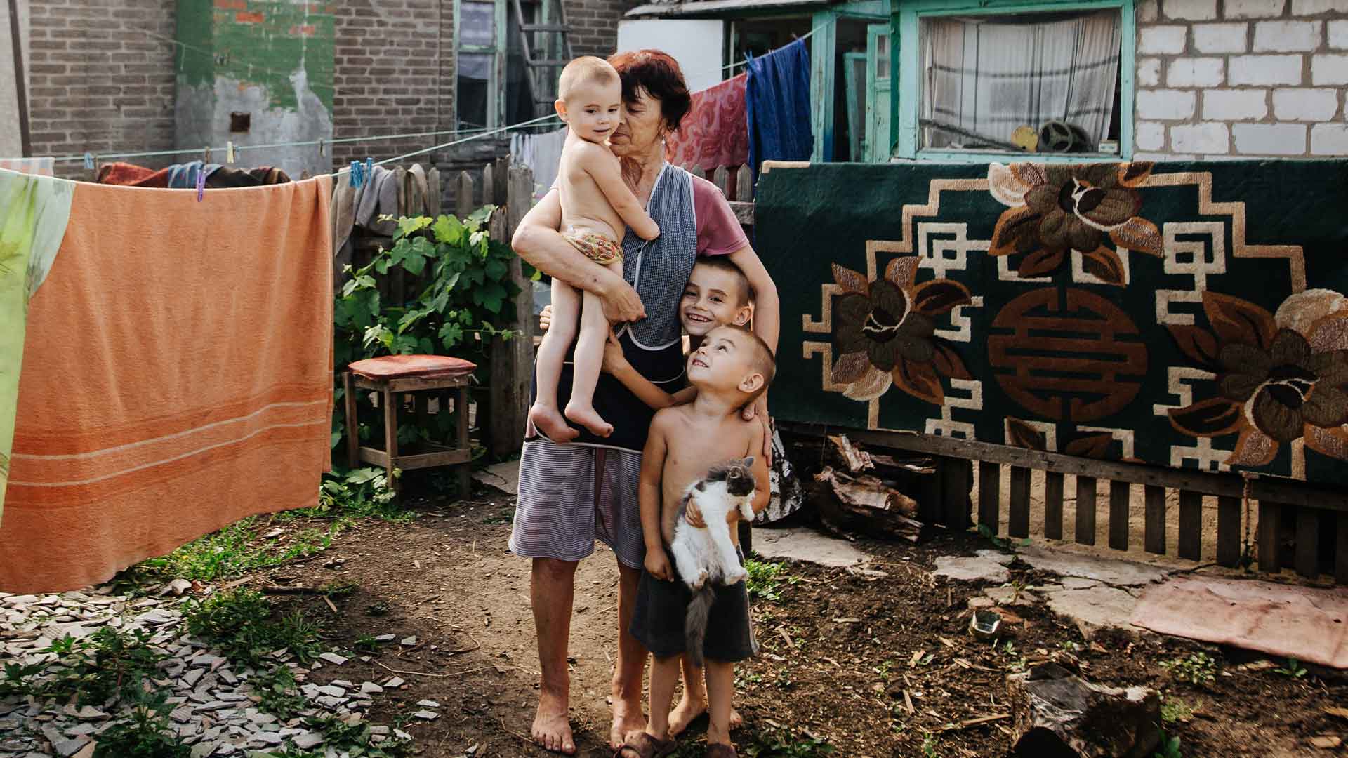 A family stand outside their home.