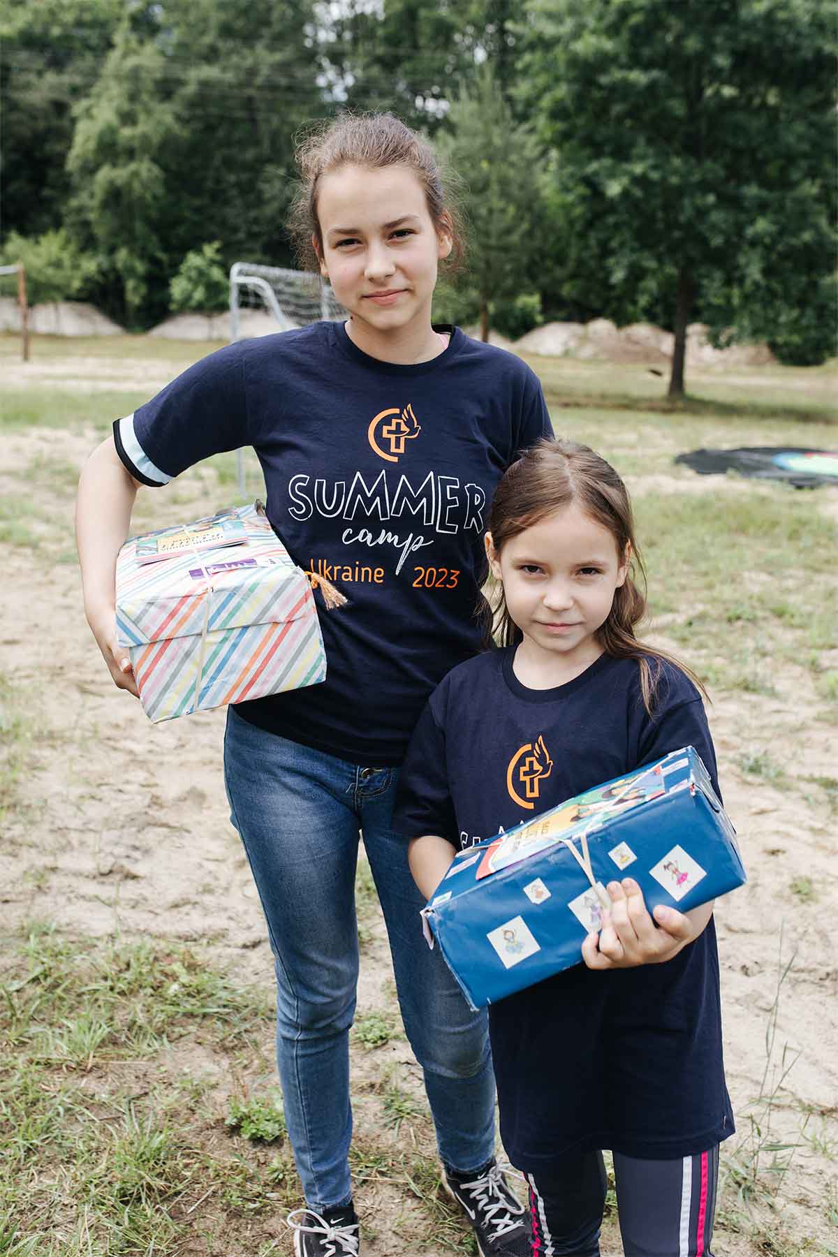 Two girls receive boxes of gifts.