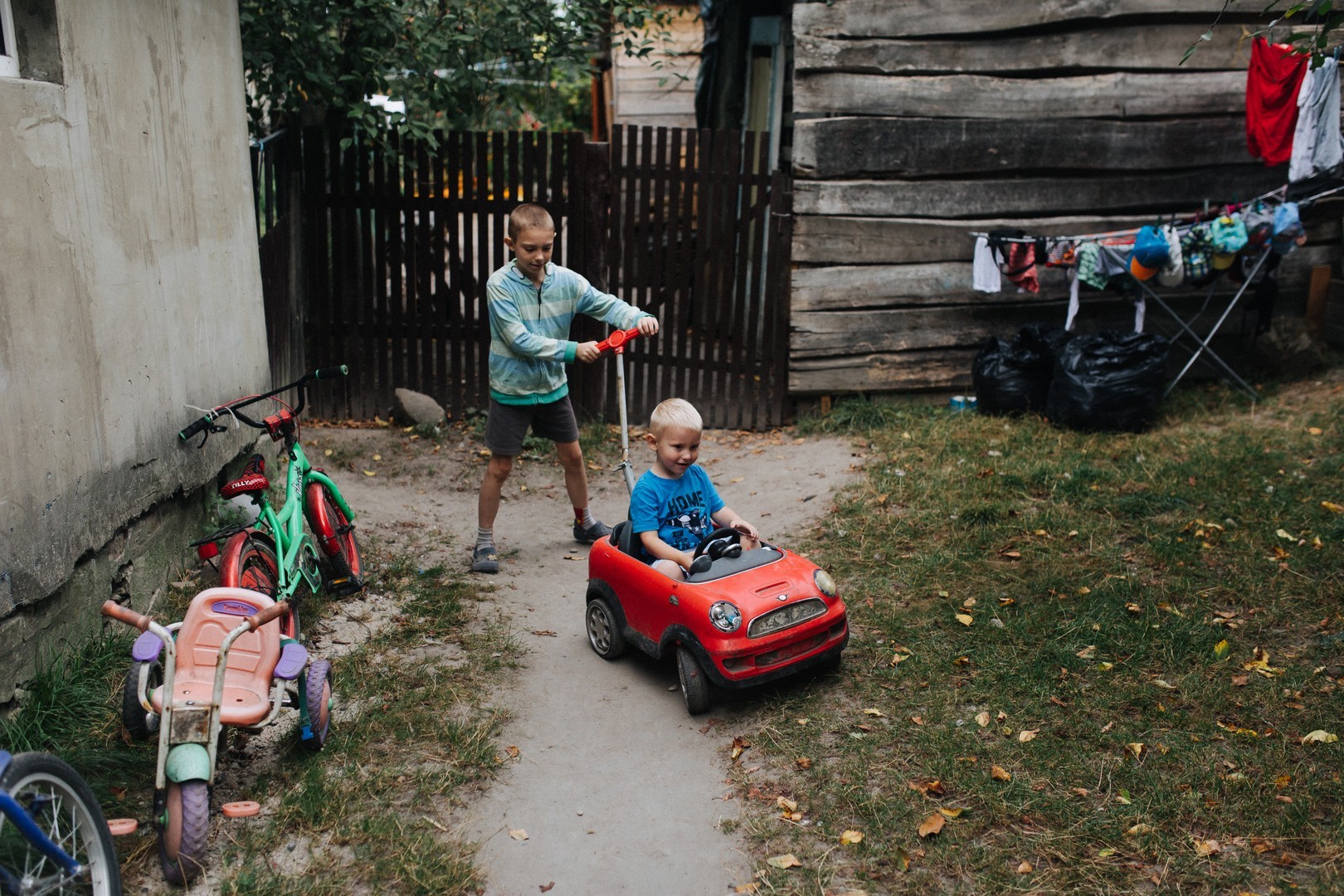 Two boys play in a small garden.
