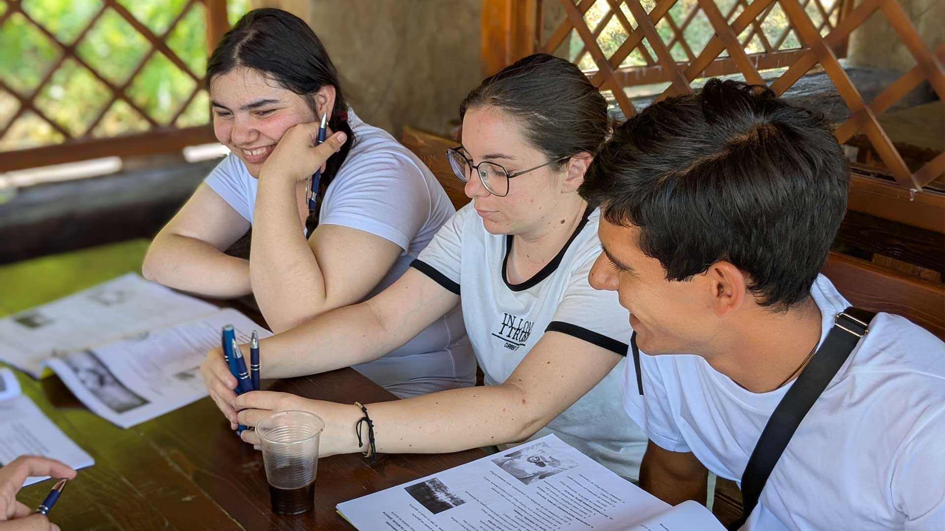 A volunteer helps with a Bible study at summer camp.