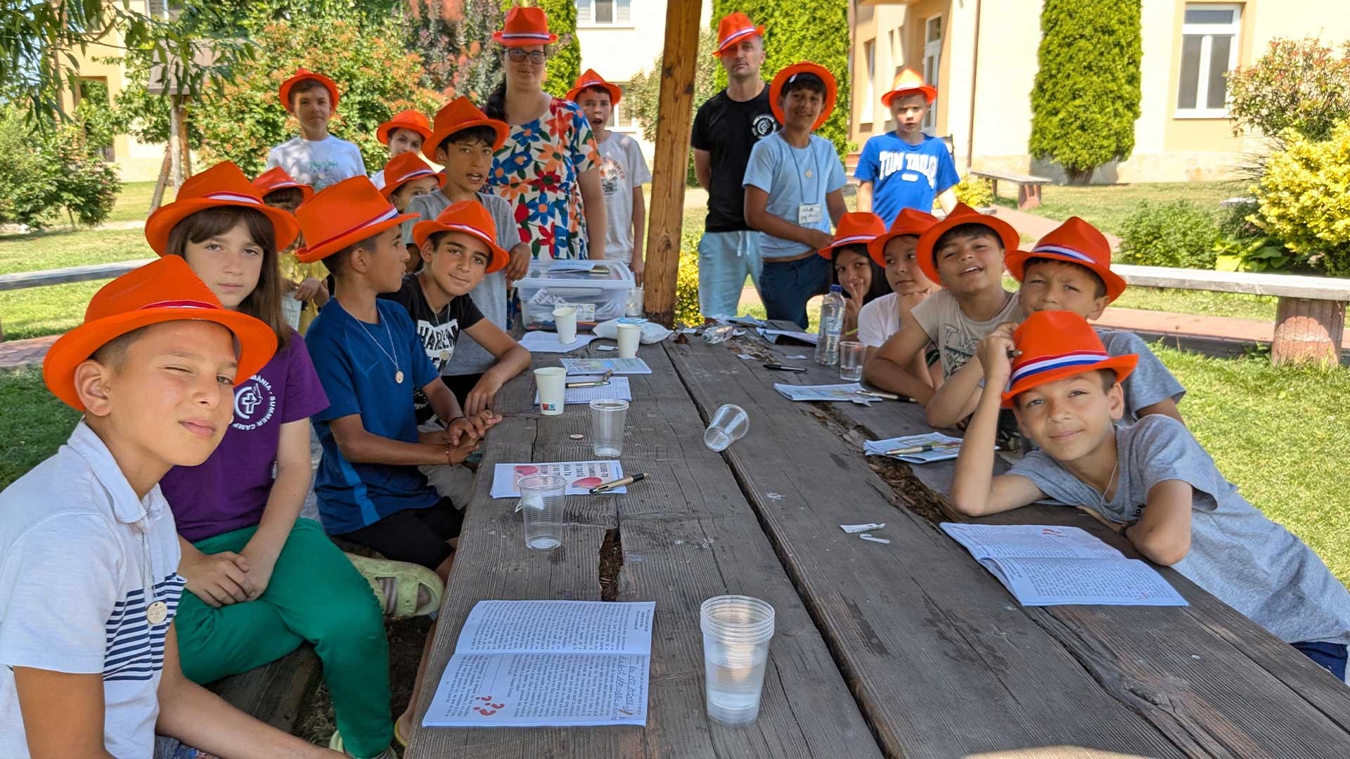 Sitting around a table in the sun at summer camp.