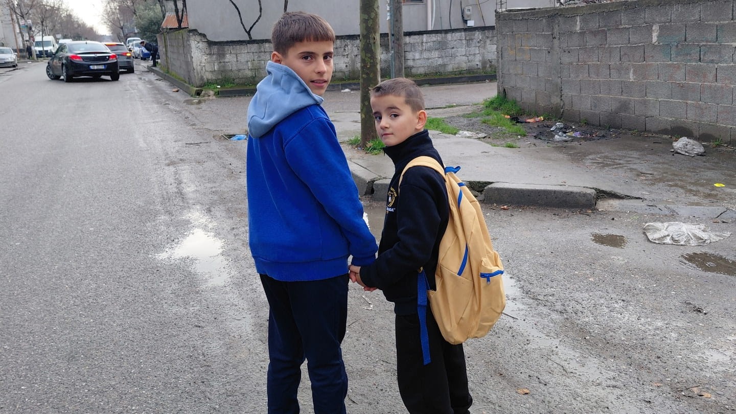 Two boys walk to school.