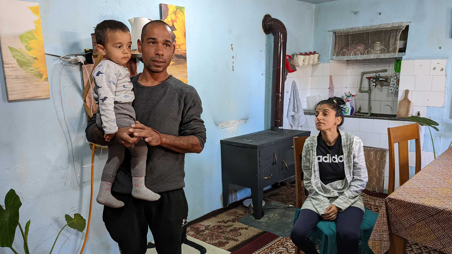 A family in their kitchen, with a wood stove.